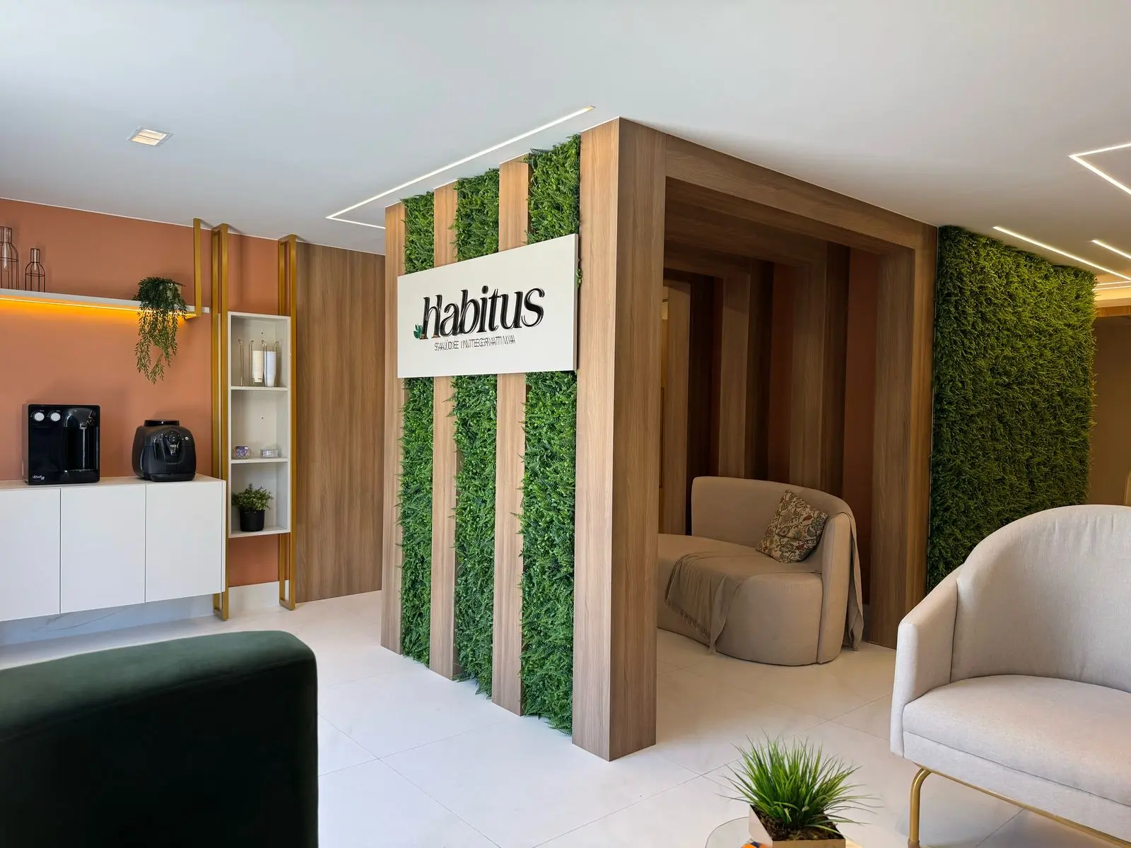 Recepção da Clínica Habitus com jardim vertical e logo